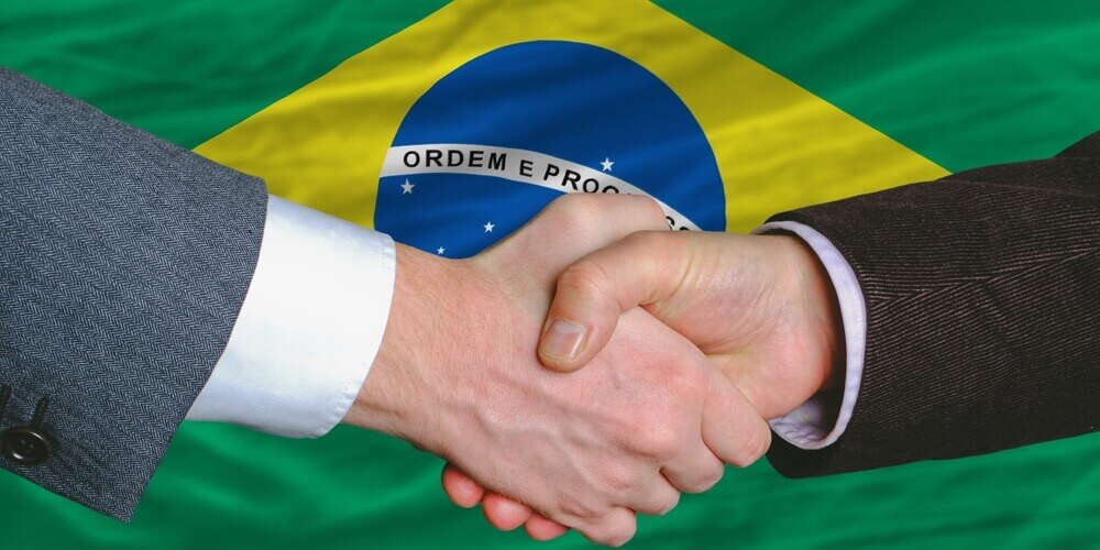 Рукопожатие на фоне флага Бразилии